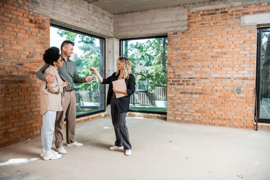 Woman property manager handing the keys to a happy couple